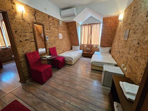 a living room with red chairs and a couch at Hotel Racic Self-Check In in Voyvodinovo