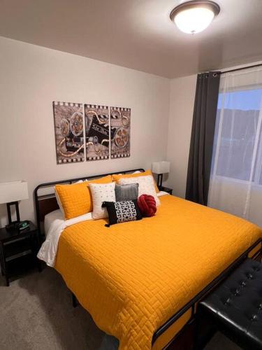een slaapkamer met een groot geel bed met kussens bij Richfield Loft Suite - Castle Rock Condos in Richfield