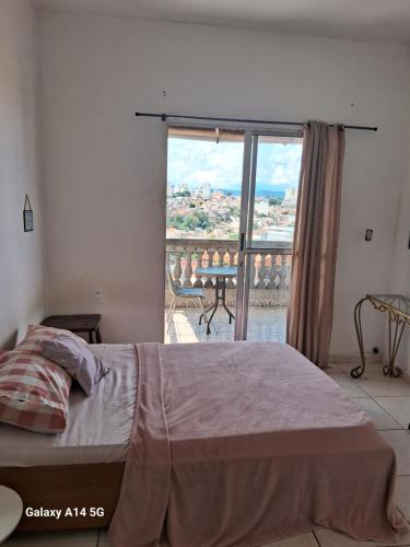 a bedroom with a bed and a view of a balcony at Kit com varanda in Sao Paulo