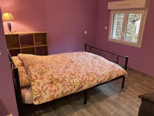 a bedroom with a bed with a blanket on it at UN PETIT COIN DE CAMPAGNE in LʼAbergement-de-Varey