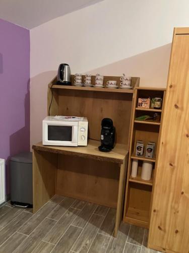 a microwave sitting on a shelf in a room at UN PETIT COIN DE CAMPAGNE in LʼAbergement-de-Varey