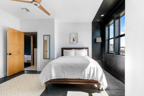 a bedroom with a bed with white sheets and a window at Celeste Rooftop Villa in New Orleans