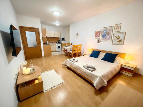 a bedroom with a large bed and a kitchen at Niko Apartments in Sunny Beach