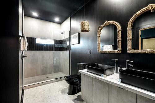 a black bathroom with a sink and a shower at Pluto Rooftop Villa in New Orleans