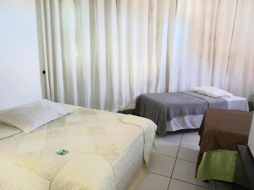 Pokój z 2 łóżkami i oknem z zasłonami w obiekcie HOTEL AL MARE ATLANTICO w mieście Aracaju