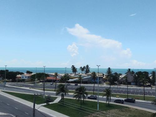 Elle offre une vue sur une rue bordée de palmiers et l'océan. dans l'établissement HOTEL AL MARE ATLANTICO, à Aracaju