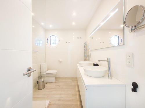 een witte badkamer met 2 wastafels en een toilet bij Villa del Prado Private Pool Large Garden in Marbella