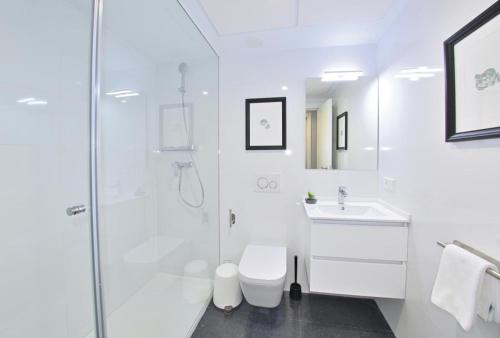 a white bathroom with a shower and a sink at Holihome Rambla 24 in Alicante