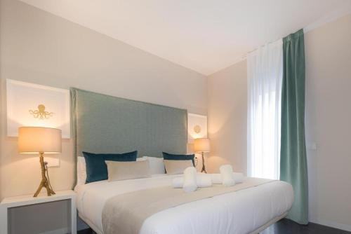 a bedroom with a large white bed with blue pillows at Holihome Rambla 24 in Alicante