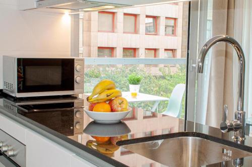 a bowl of fruit on a counter in a kitchen at Holihome Rambla 24 in Alicante