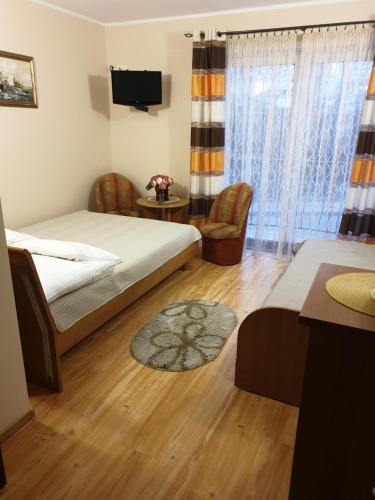 1 dormitorio con 1 cama, mesa y sillas en Słoneczny Dworek en Dąbki