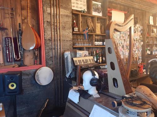 a room with a bar with a harp and other items at Guesthouse Holmur in Hólmur