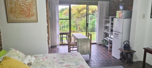 a living room with a couch and a kitchen with a window at Secret Sithela in Port Edward
