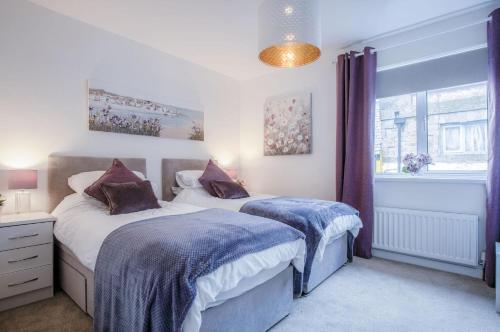 een slaapkamer met 2 bedden en een raam bij Luxurious Apartment Charlton Mews - 2 Bed - Tenby in Tenby