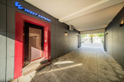 an empty hallway with a red door in a building at Central Park Apartments - The Luxury Collection in Kaunas
