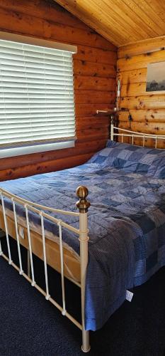 um quarto com uma cama num chalé de madeira em Snowdonia National park Log cabin with garden em Trawsfynydd