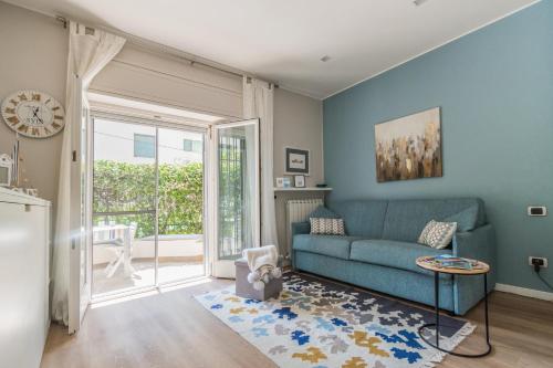 a living room with a blue couch and a table at Ariston & Casinò - Appartamento con Giardino e Garage in Sanremo