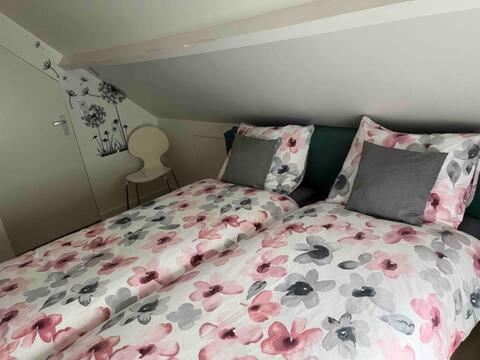 a bedroom with a bed with pink flowers on it at Enjoy Heuvelland in Simpelveld