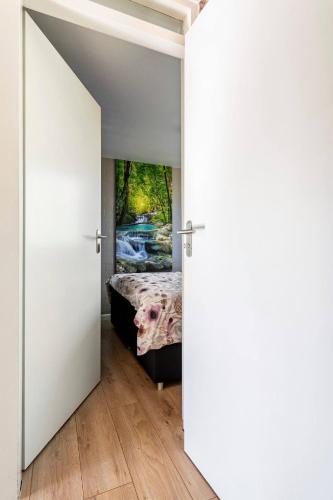 an open door leading to a bedroom with a bed at Enjoy Heuvelland in Simpelveld
