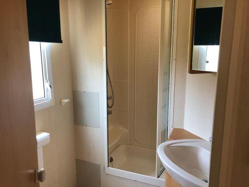een badkamer met een douche, een wastafel en een toilet bij 2 bedroom static caravan in Muirkirk