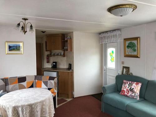 een woonkamer met een bank en een tafel bij 2 bedroom static caravan in Muirkirk