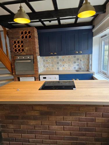 une cuisine avec des placards bleus et un comptoir dans l'établissement Bournemouth secluded cottage 10mins walk to beach, à Bournemouth