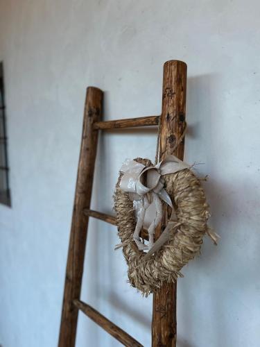 a wooden cross with a wreath on a wall at Il Glicine - Natural BnB in Castello di Godego