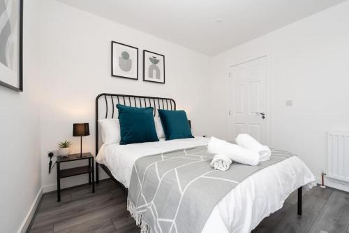 ein weißes Schlafzimmer mit einem Bett mit blauen Kissen in der Unterkunft Perfect Modern 4 bedroom in Liverpool in Liverpool