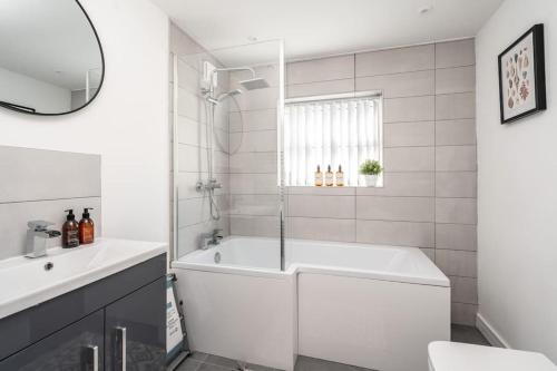 a white bathroom with a tub and a sink at Perfect Modern 4 bedroom in Liverpool in Liverpool
