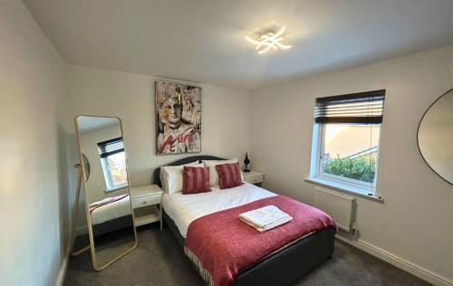 - une petite chambre avec un lit et un miroir dans l'établissement Bracknell Contemporary Stylish 3 bedroom in, à Bracknell