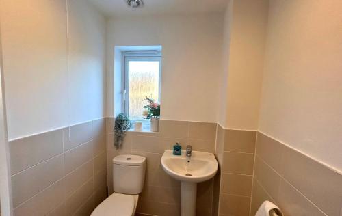 La salle de bains est pourvue de toilettes et d'un lavabo. dans l'établissement Bracknell Contemporary Stylish 3 bedroom in, à Bracknell