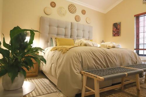a bedroom with a large bed and a potted plant at Sandy Creek Safaris in Kransberg
