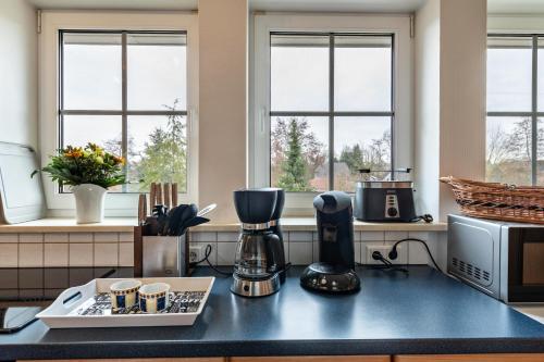 a kitchen with a counter with a coffee maker and windows at Ferienwohnung Krakow am See in Krakow am See