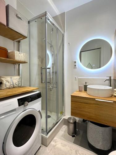 une salle de bain avec douche et machine à laver dans l'établissement L' appartement Blomet, à Paris
