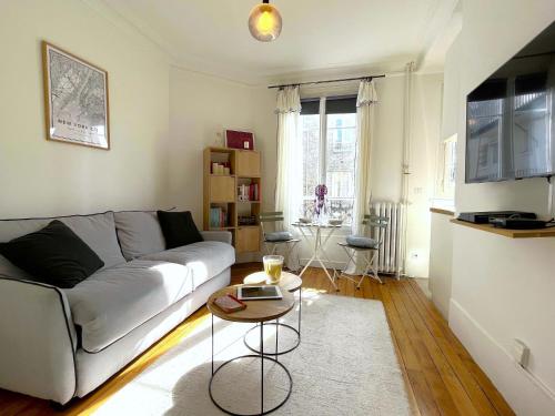 un salon avec un canapé et une table dans l'établissement L' appartement Blomet, à Paris