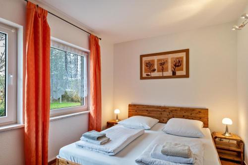 a bedroom with two beds and two windows at Ferienhaus Krakow am See in Krakow am See