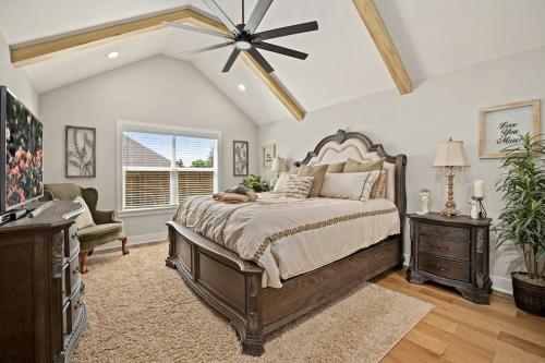 een slaapkamer met een groot bed en een plafondventilator bij Copper Creek Retreat - Hot Tub - Fenced In Yard in Fayetteville