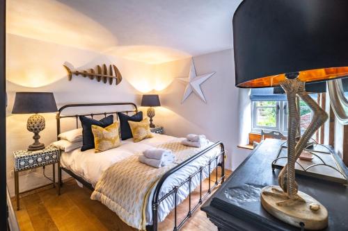 a bedroom with a bed and a table with a lamp at Fox Cottage in South Creake