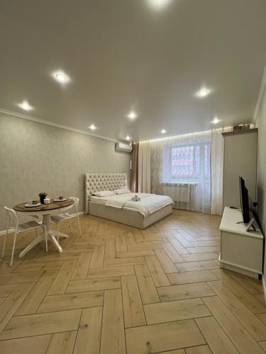 a bedroom with a bed and a table and a desk at Байзакова 133 in Pavlodar
