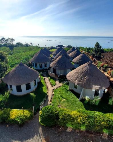 Vue aérienne d'un groupe de cabanes avec l'océan dans l'établissement Galore Luxury Resort, à Maseno