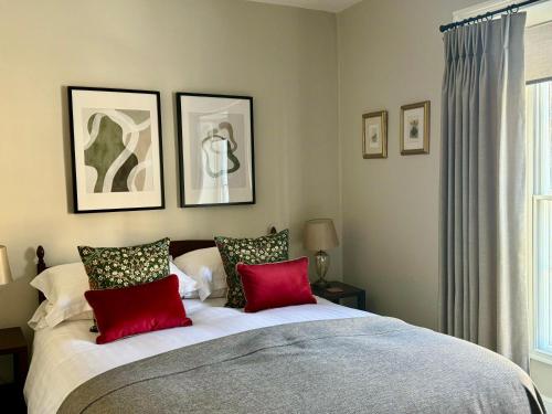 a bedroom with a large bed with red pillows at Bramwood Guest House in Pickering