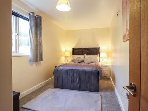 a bedroom with a bed and a window at May Cottage in Llanfyllin