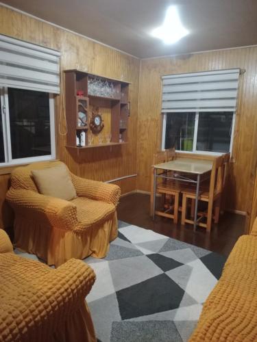 sala de estar con mesa de ping pong y sillas en Cabañas Carmencita, en Puerto Puyuhuapi