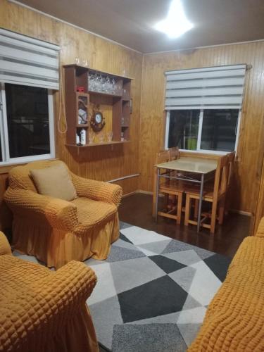 sala de estar con mesa y 2 sillas en Cabañas Carmencita, en Puerto Puyuhuapi