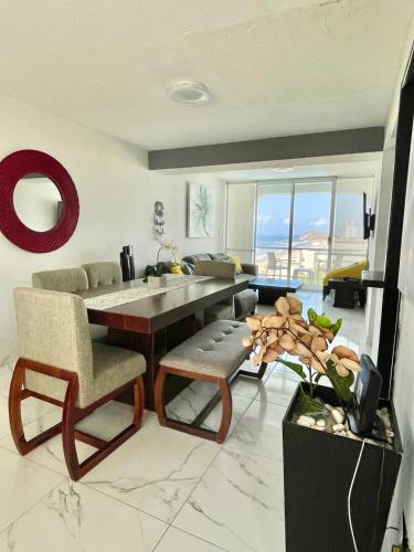 ein Wohnzimmer mit einem Tisch, Stühlen und einem Sofa in der Unterkunft Departamento con vista al mar in Mazatlán