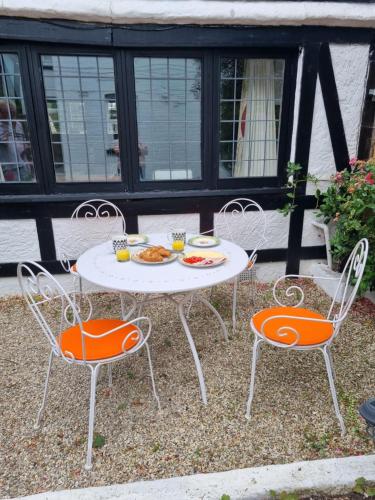 a table and two chairs with a plate of food on it at Bournemouth secluded cottage 10mins walk to beach in Bournemouth