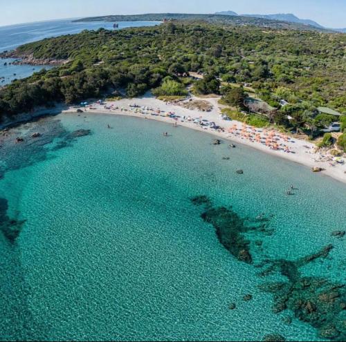 an aerial view of a beach with people in the water at Cala Ginepro Tortoli in Bari Sardo