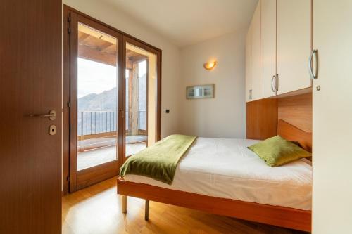 1 dormitorio con 1 cama y balcón en Willow Apartment with Lakeview by Wonderful Italy, en Gravedona