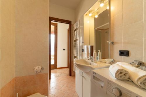 een badkamer met een wastafel en een spiegel bij Willow Apartment with Lakeview by Wonderful Italy in Gravedona