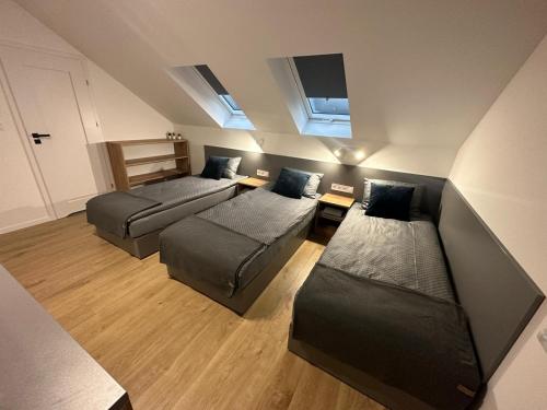 Cette chambre comprend 2 lits et un canapé. dans l'établissement Noclegi Pniów 51, 